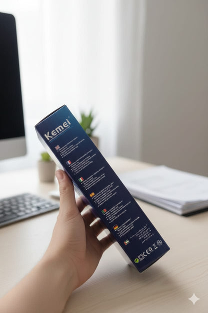 Hand holding a Kemei box on a desk with a blurred background